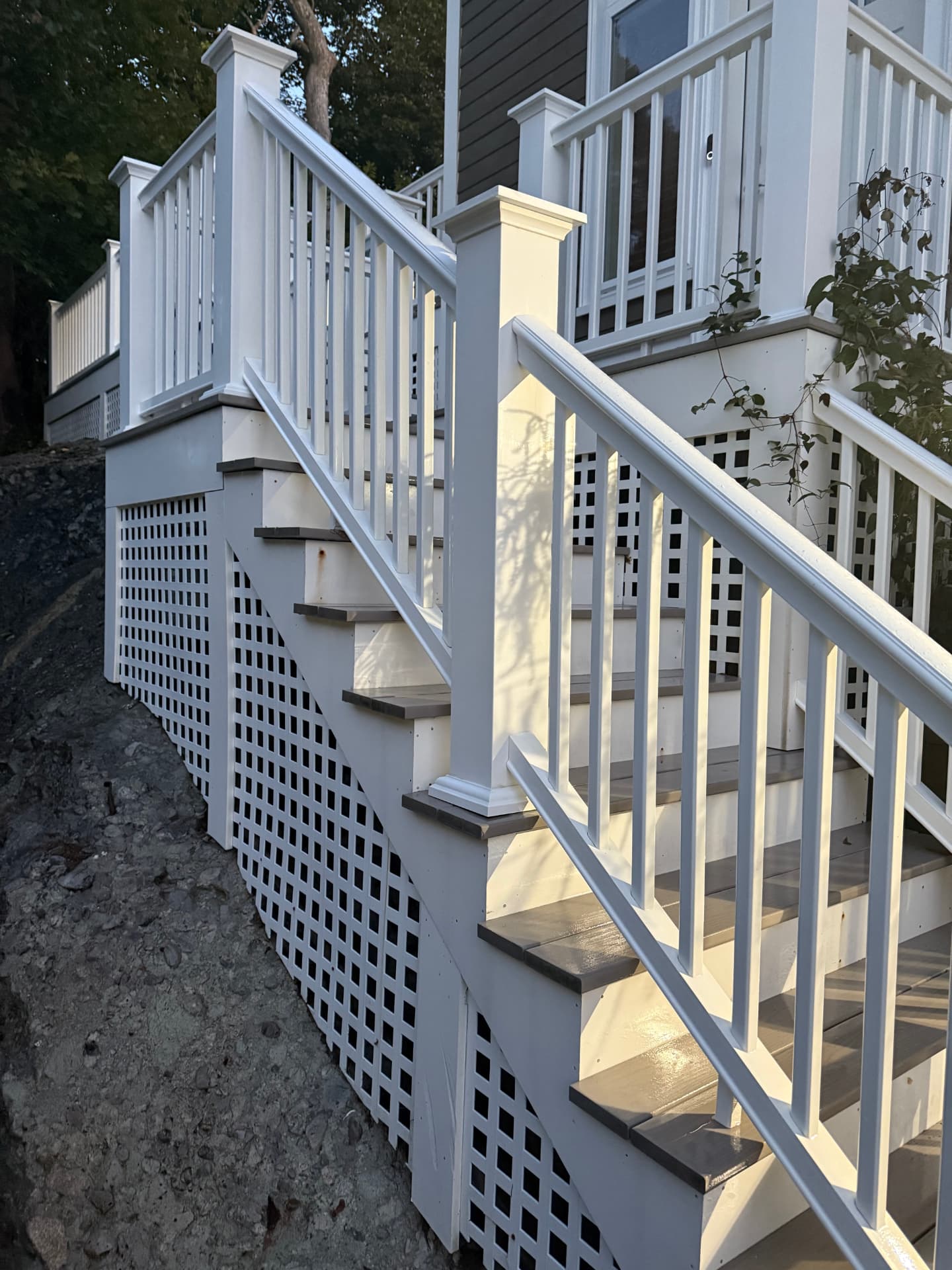 The same staircase, railings, and lattice restored to bright white after washing