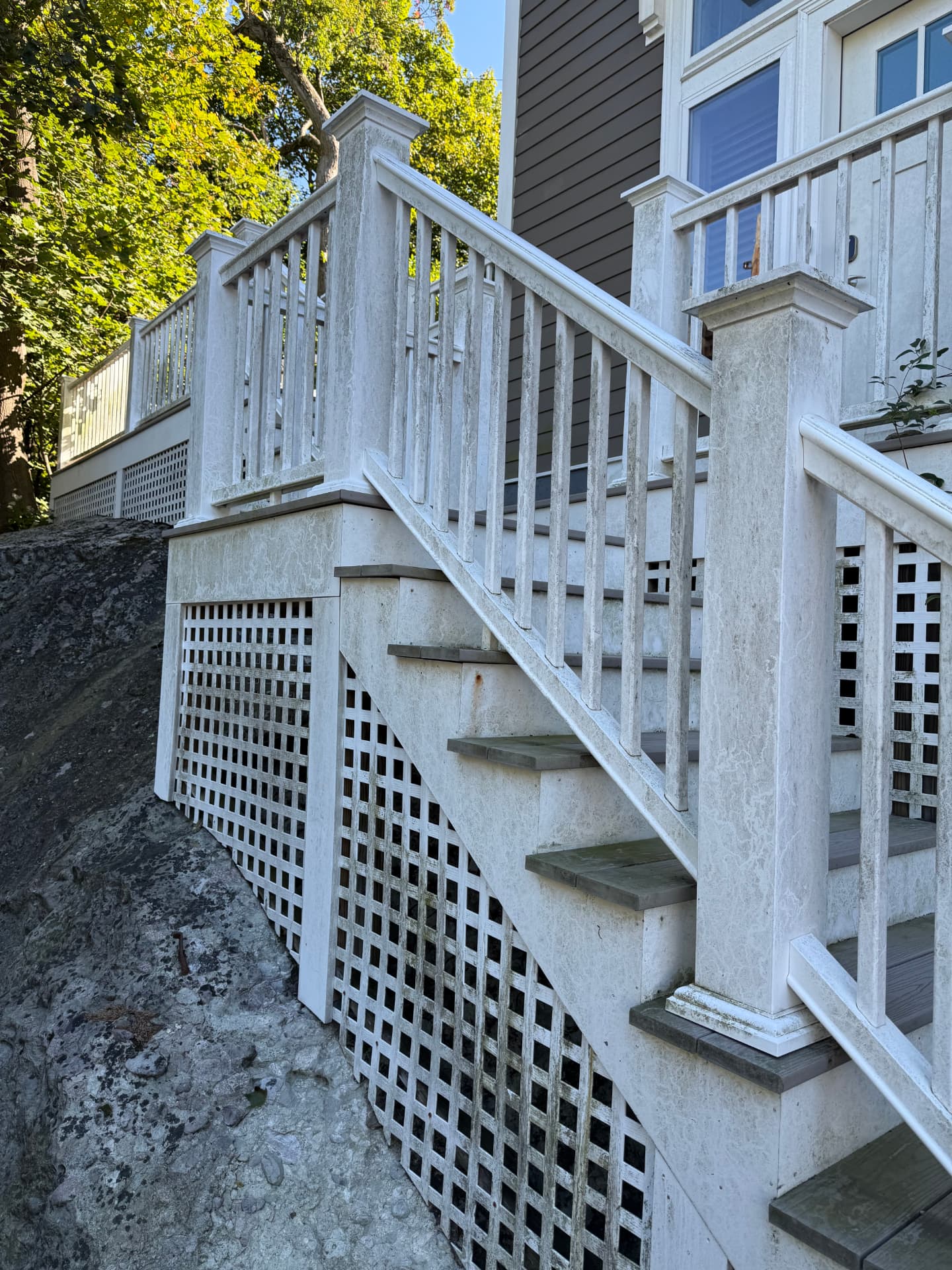 Deck staircase, railings, and lattice skirting gray with mildew before cleaning